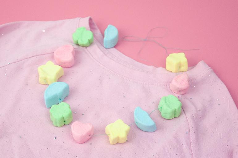Marshmallow necklace activity on top of a t-shirt